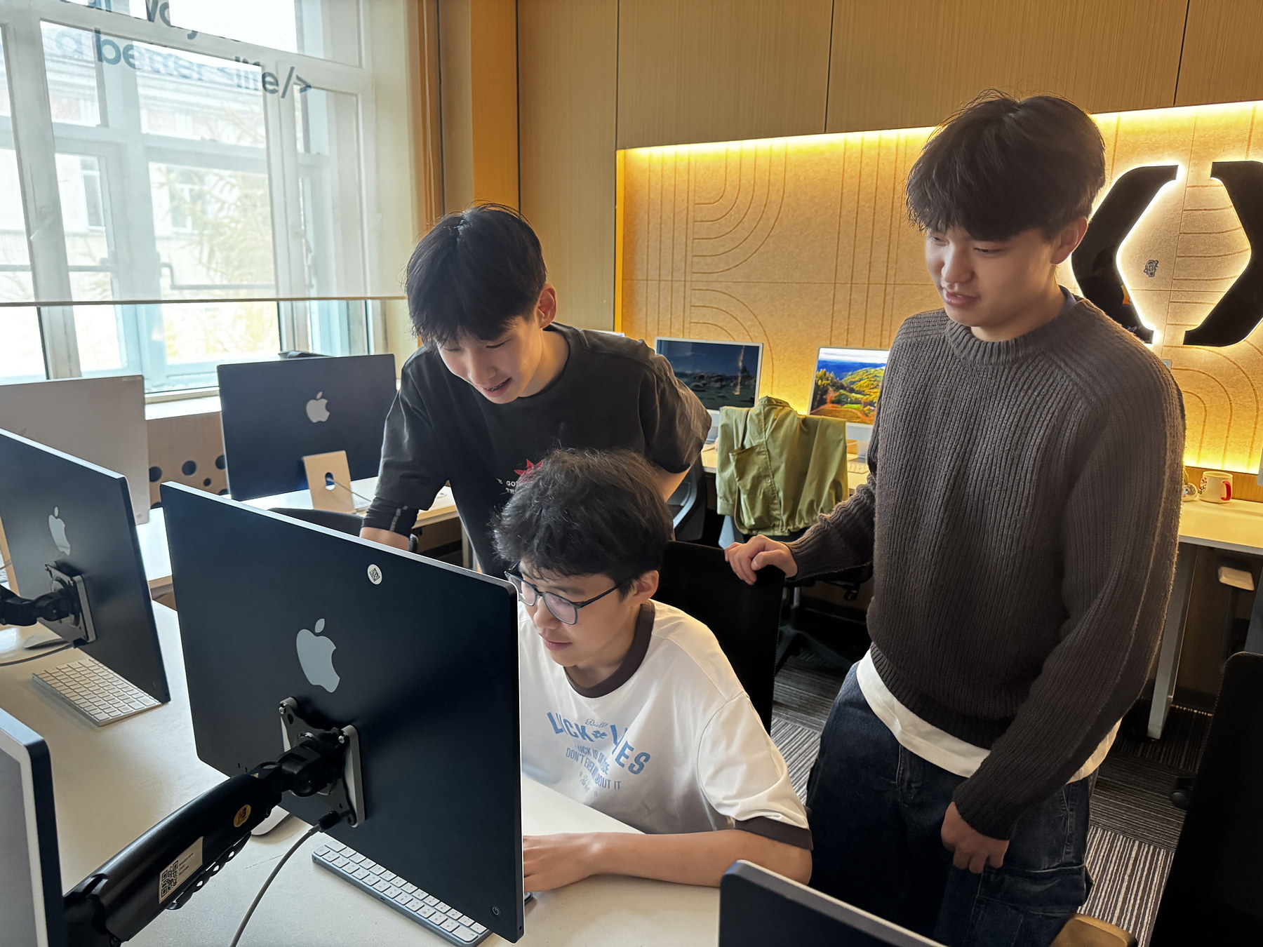 A mentor and two students review a program together