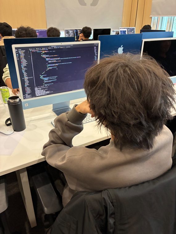 A student reads through his code on an iMac